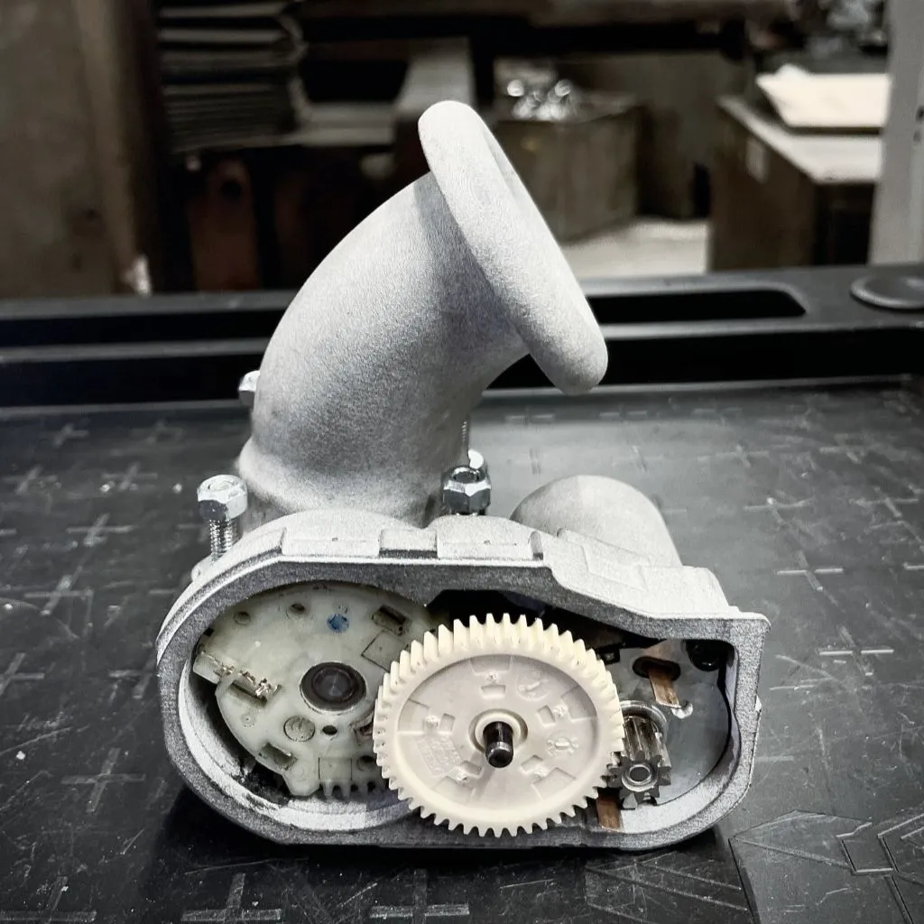 Obudowa przepustnicy do bolidu wykonana w technologii druku 3D z polimerów - precyzyjne rozwiązanie od Spes3D wspierające optymalizację układu dolotowego bolidu wyścigowego.